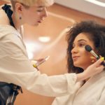 Charming lady getting professional makeup in beauty salon