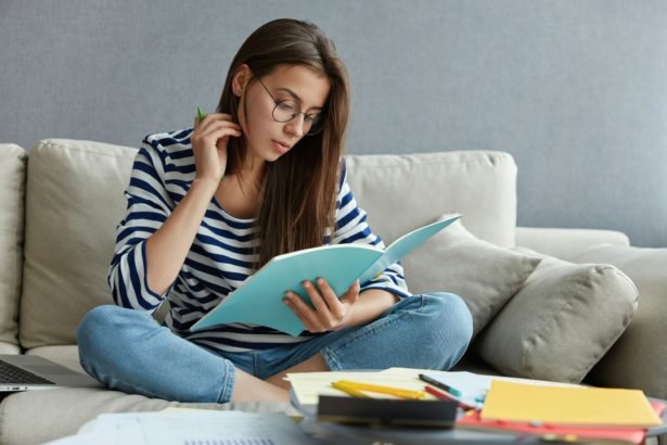 Education and exam preparation concept. Dark haired attractive woman underlines importnant informati